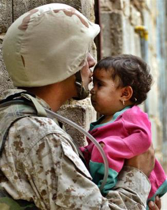 Soldier kisses Iraqi Child on forehead
